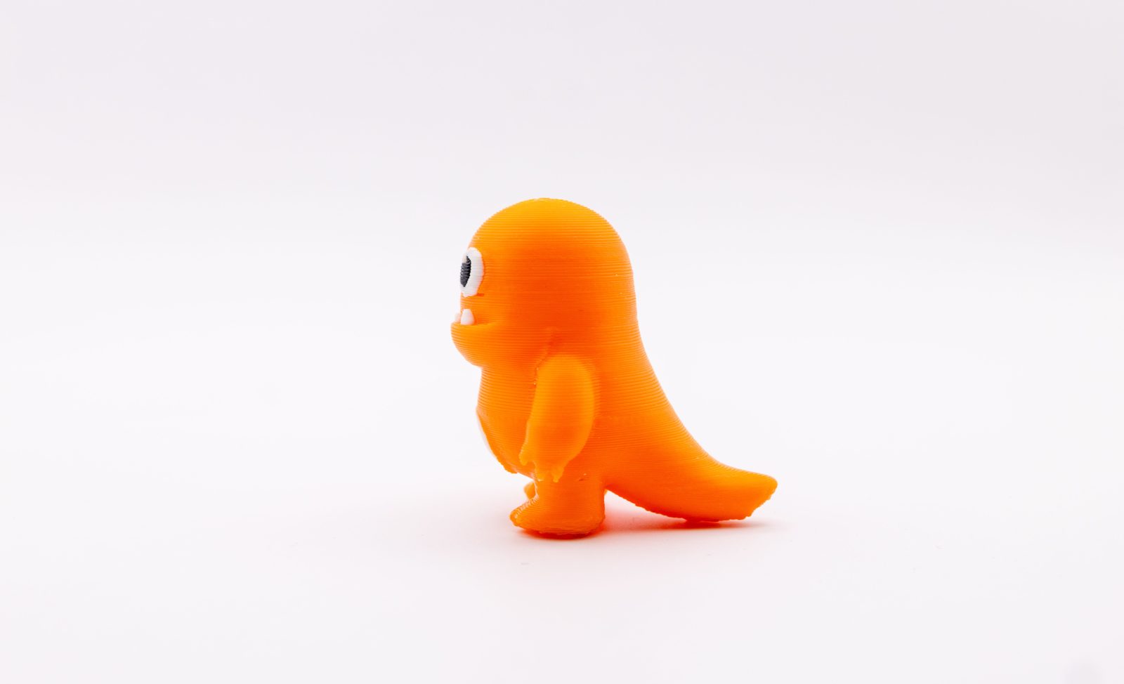 Bonequinho de dinossauro laranja de plástico visto de lado, com finas listras horizontais em toda a superfície e pequenas rebarbas no braço e no rabo