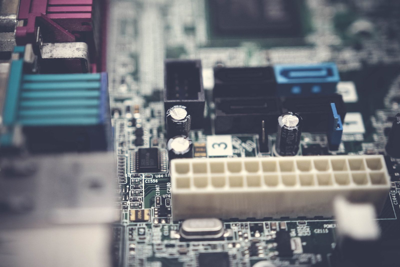 Close de uma placa eletrônica com conectores de encaixe vazios e capacitores