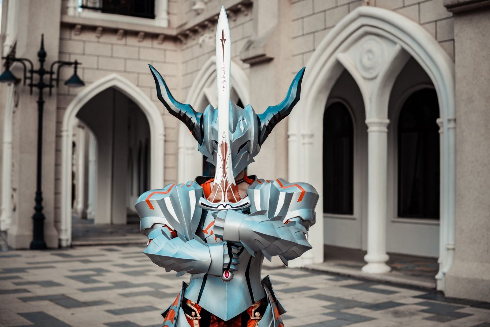 Cosplay de armadura completa prateada, com capacete de chifres e peitoral inteiros, em frente a um prédio de arcos — o tipo de peça grande que uma mesa de 420 mm imprime sem cortar