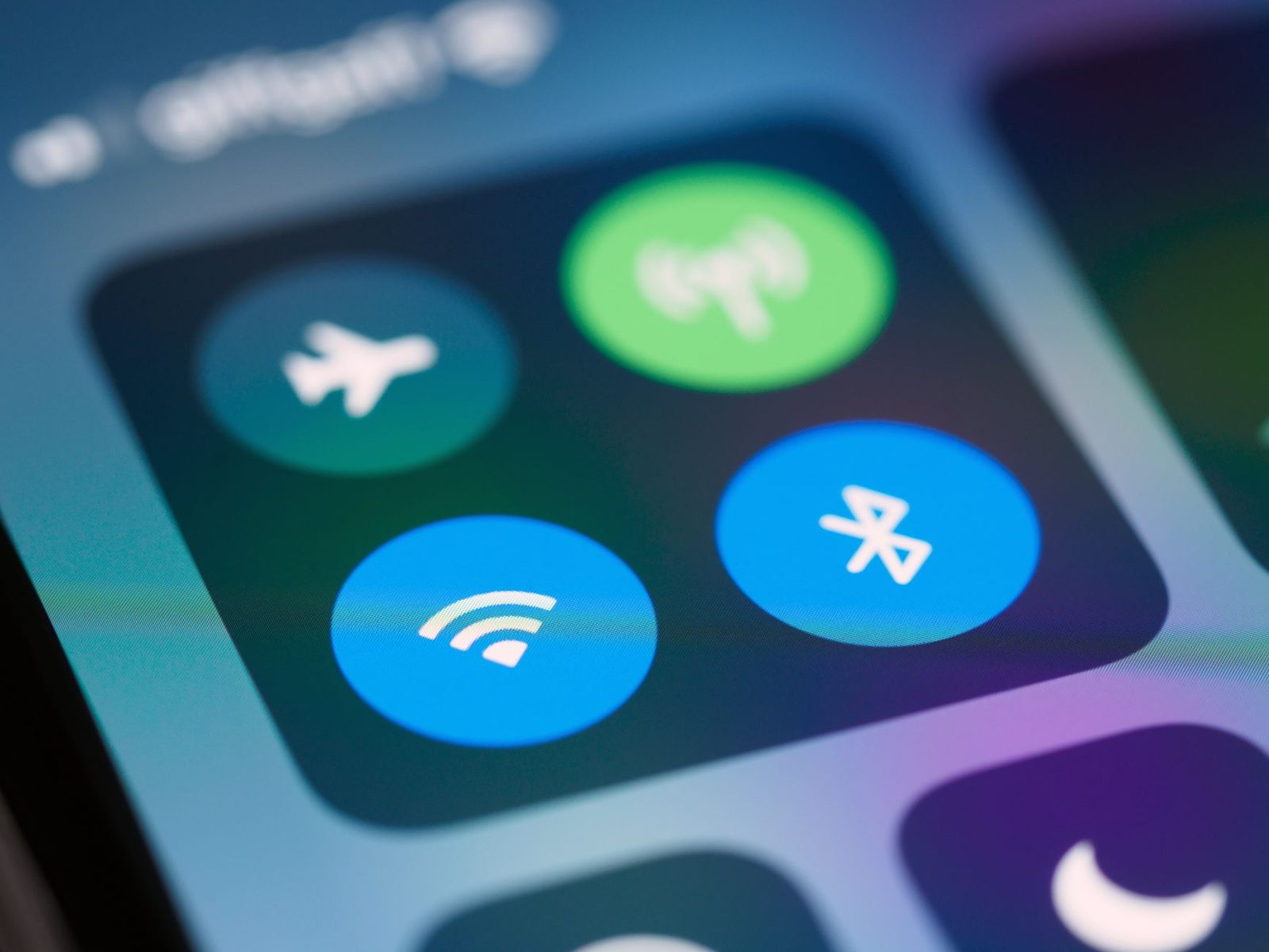 Close da tela de um celular com o botão de Wi-Fi ligado, ao lado dos botões de Bluetooth e modo avião
