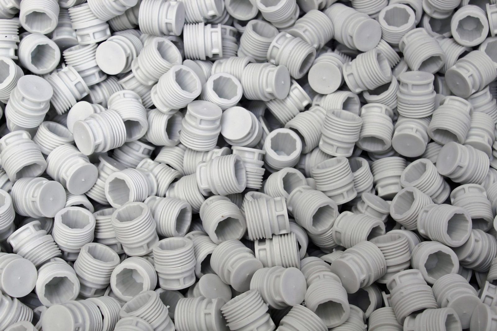 Muitas peças pequenas produzidas em lote — a mesa cheia é o que dilui o custo