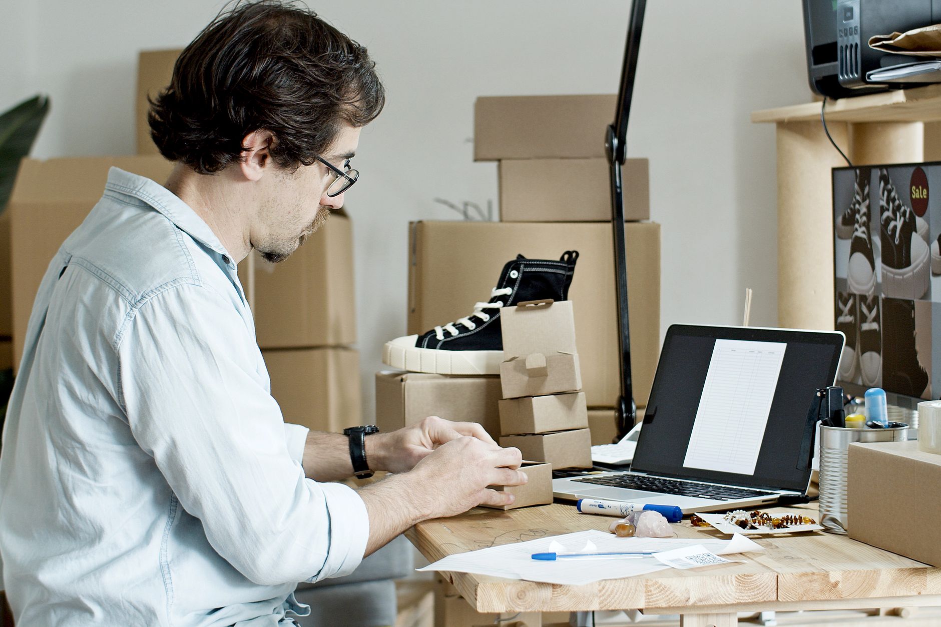 Empreendedor embalando pedidos pequenos para envio, etapa de venda no marketplace
